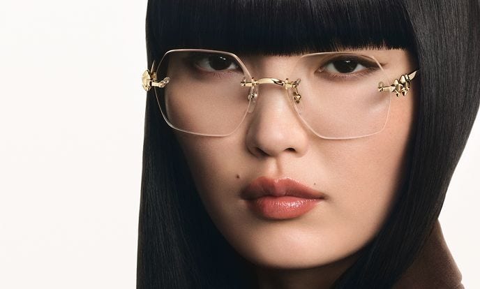 A woman wearing rimless Cartier glasses with gold panther temples