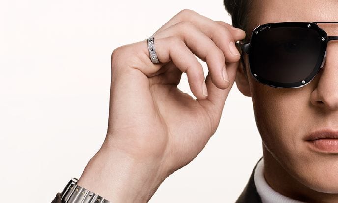 A man adjusting double-bridge Cartier Santos sunglasses