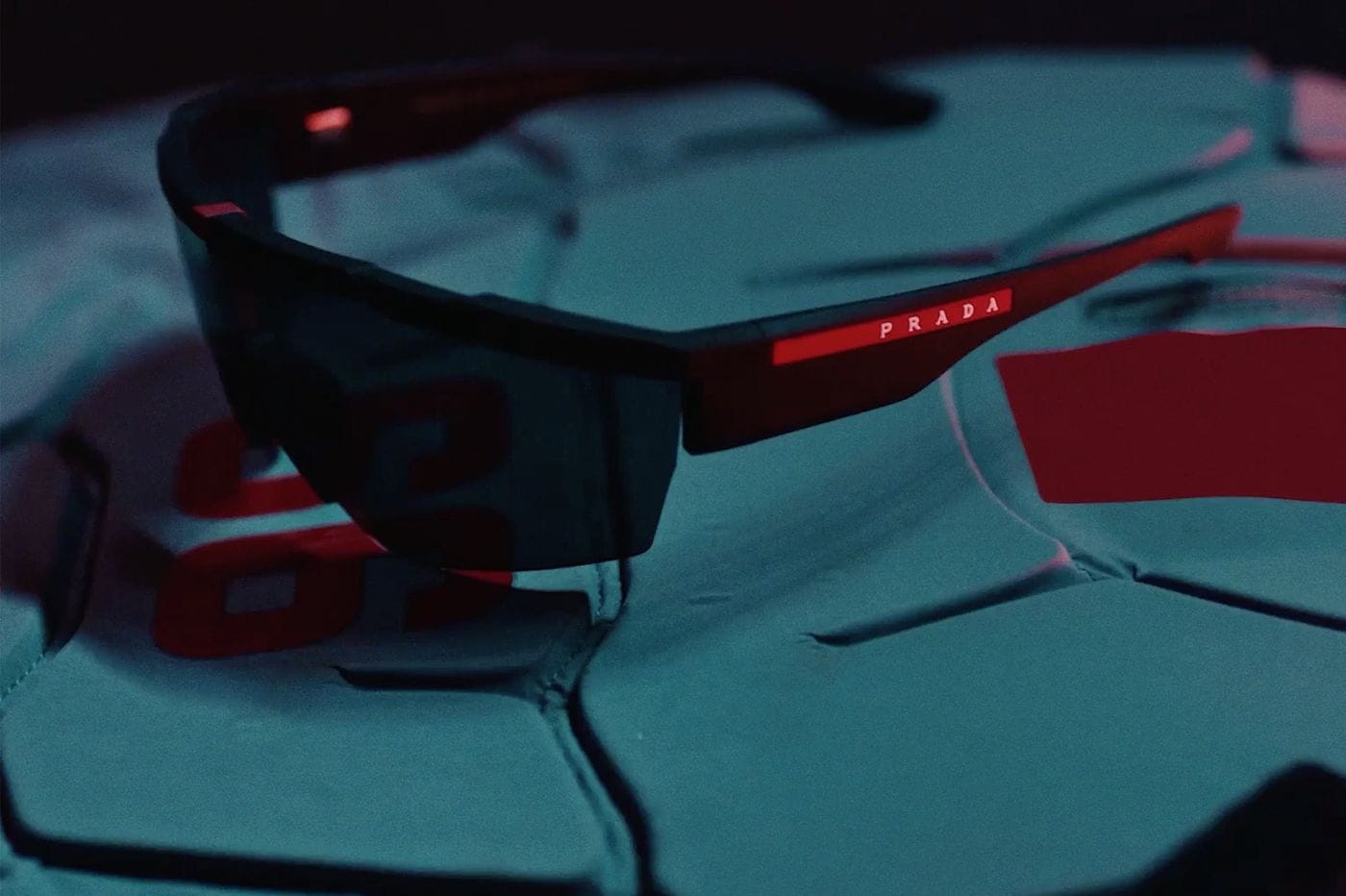 Close-up of Prada Linea Rossa sunglasses with the red logo on the temple