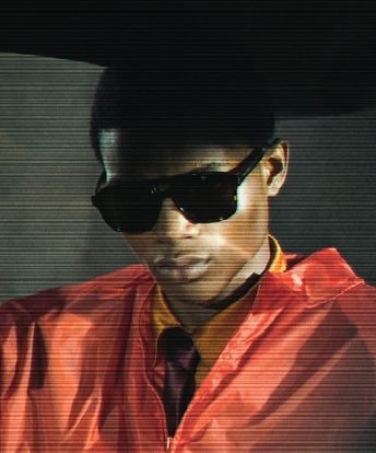 A man in Saint Laurent sunglasses and a red jacket from the Spring-Summer 2026 campaign