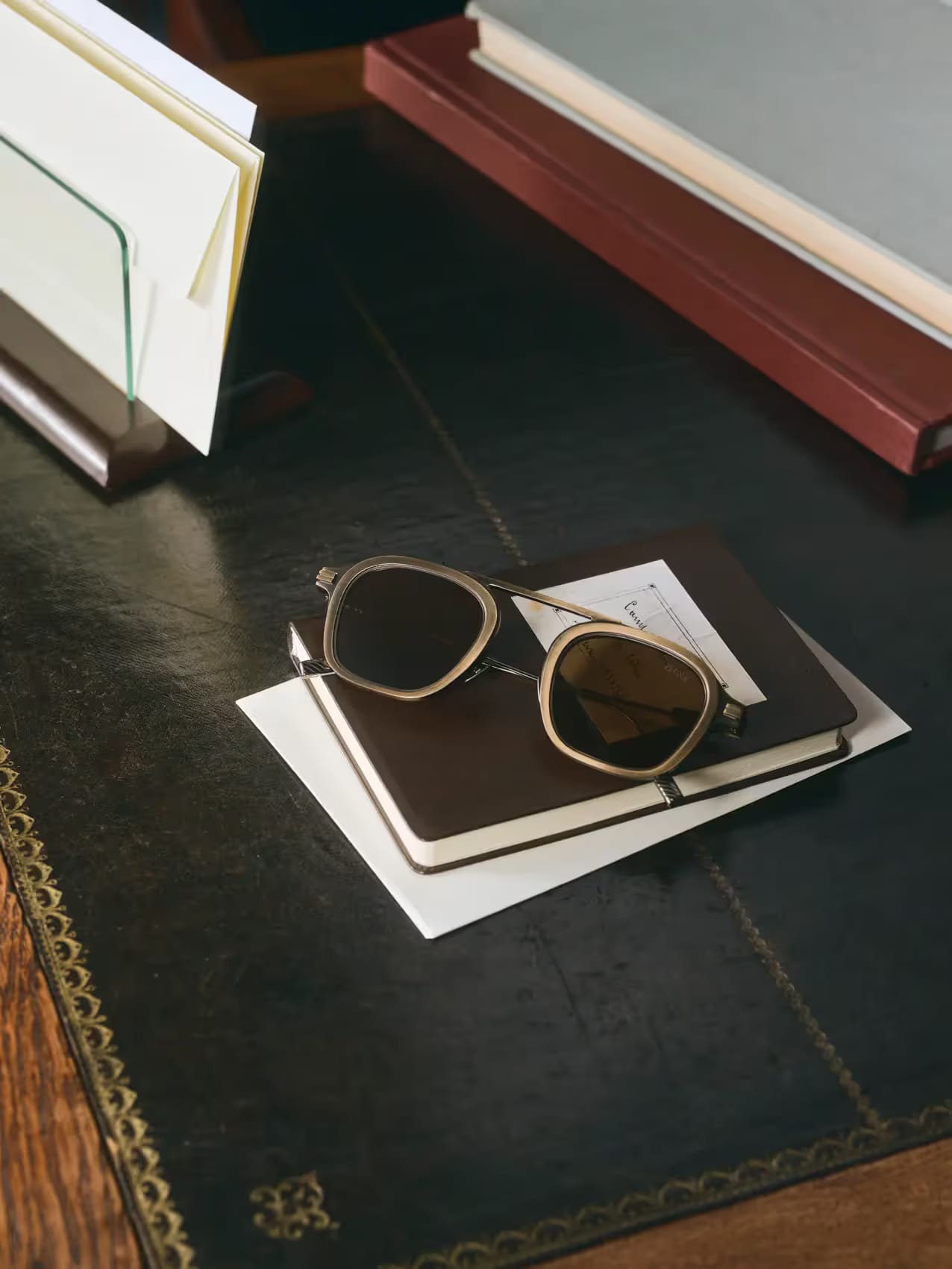 Zegna titanium sunglasses resting on a leather desk